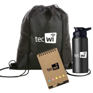 Kit de brinde corporativo com mochila da cor preta com letras brancas, garrafa preta com letras brancas e cardeneta de anotações de cor beje com letras pretas e marcadores coloridos, com uma uma pequena caneta beje com tampa e ponta pretas anexado na própria cardeneta.